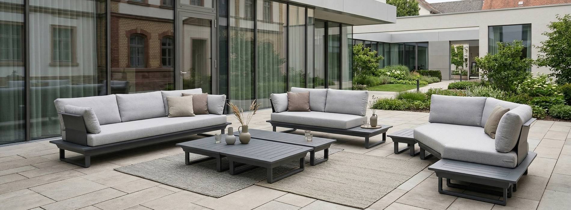 Modulare Gartenlounge aus verschiedenen Sitzmodulen, kombiniert zu einer großzügigen Sitzlandschaft im Außenbereich.
