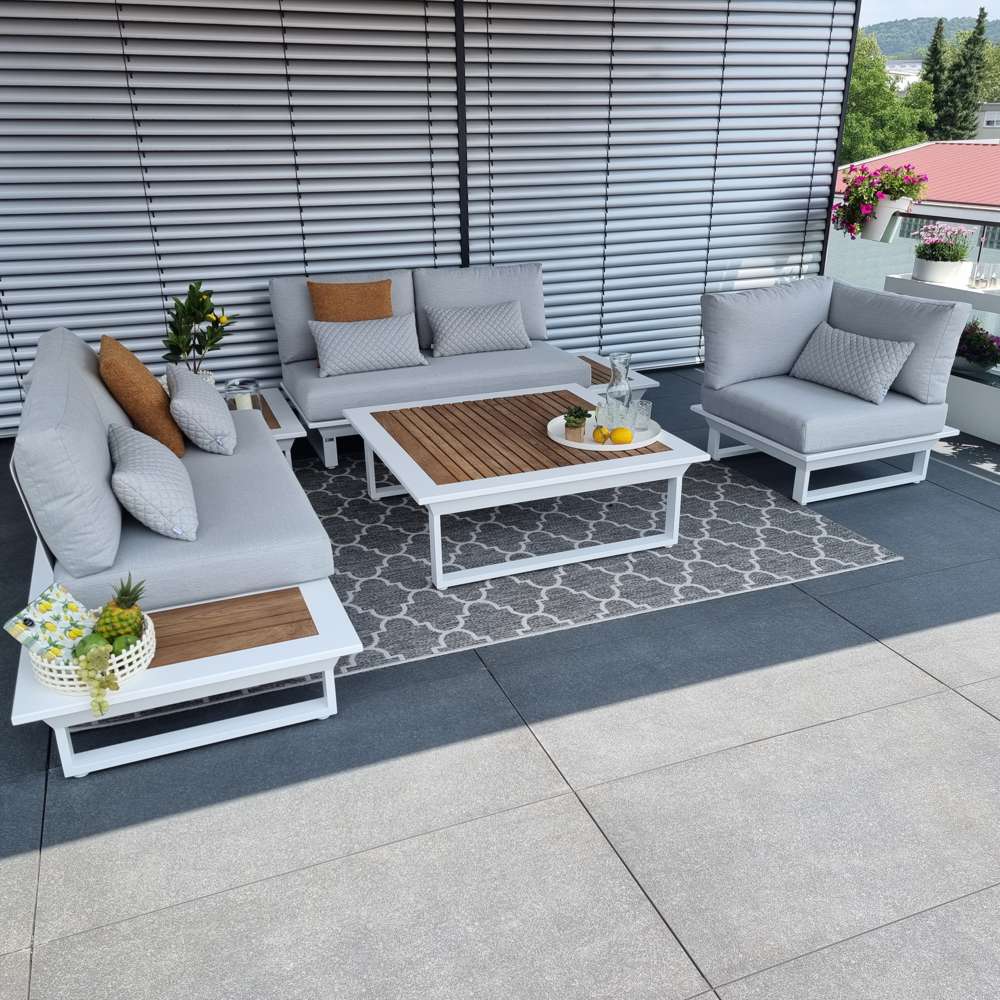 Weiße Outdoorlounge in Aluminium mit Teakholztisch und integriertem Seitentisch.