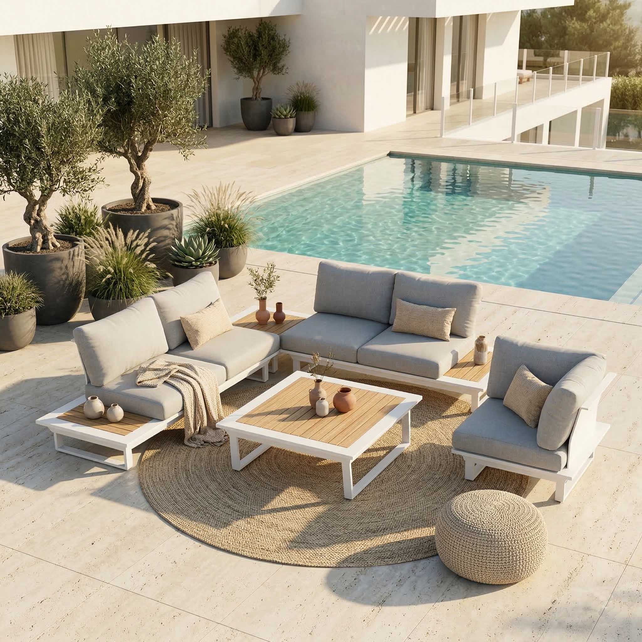 Cannes Outdoor-Lounge Set – Offene Anordnung in Weiß Modulare Cannes Outdoor-Lounge Kombination aus zwei 2-Sitzer Modulen mit integriertem Tisch, Kaffeetisch, Eckmodul als Sessel gegenüber und Loungetisch in der Mitte, weißes Aluminium mit Teak-Tischplatten auf Terrasse vor Haus mit Pool